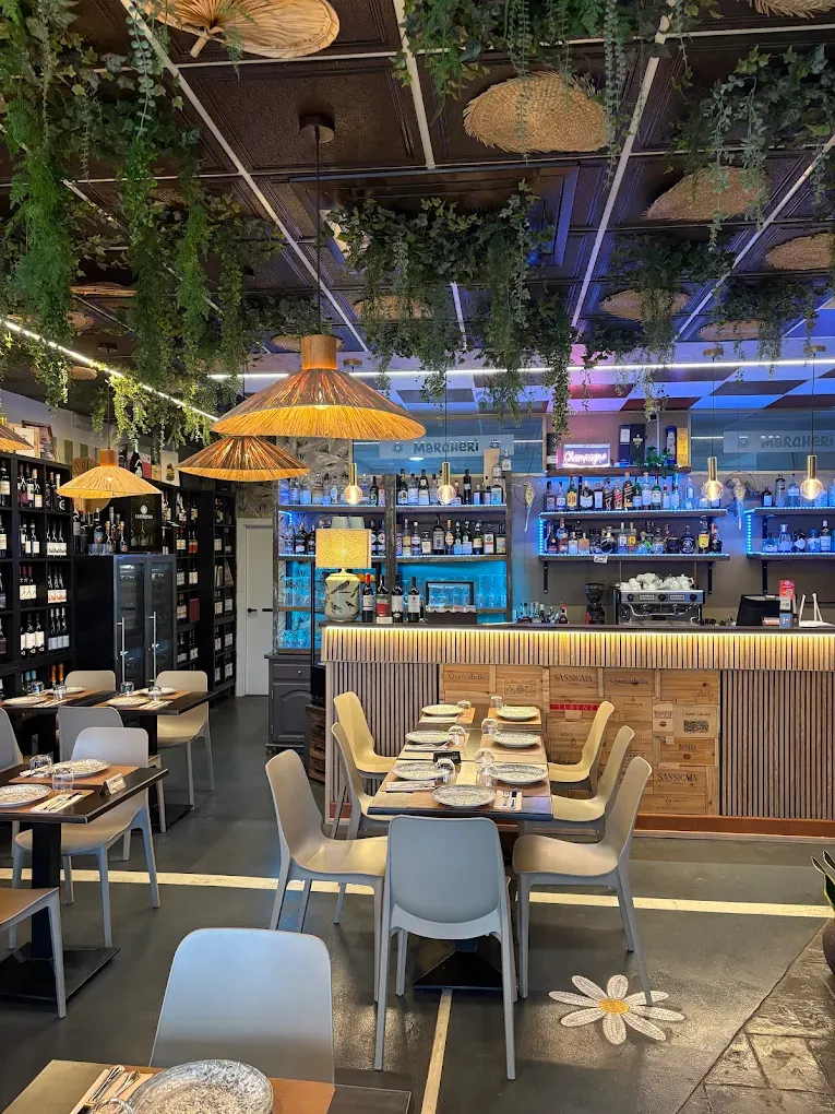 The dining room at Margherì Estepona with rattan lights and a painted checkerboard ceiling