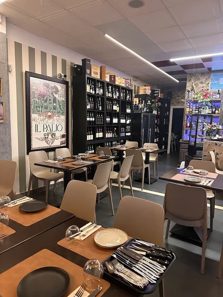 Tables laid with cutlery, wine shelves behind